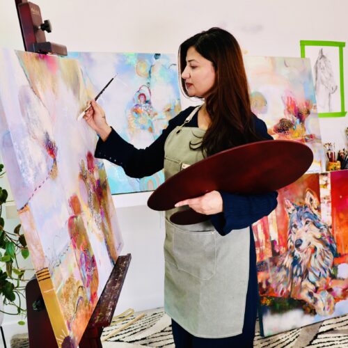 Tabassum Malani painting at her easel in her Melbourne studio